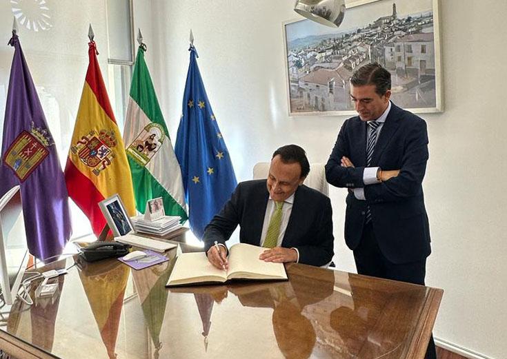 Villamandos firma en el libro de honor del Ayuntamiento de Baeza en presencia del alcalde.